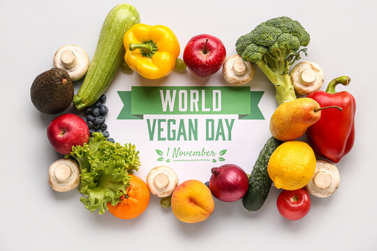 Card with text WORLD VEGAN DAY 1 NOVEMBER, fresh vegetables and fruits on grey background - Powered by Adobe