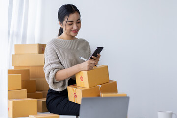 Startup small business entrepreneur SME, asian woman receive order on phone. Success young Asian small business owner home office, online sell marketing delivery, SME e-commerce telemarketing concept
