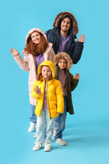 Happy family in puffer jackets on blue background