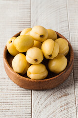 Ripe juicy sweet apricots in a wooden plate on a light wooden background. Fruit and harvest 