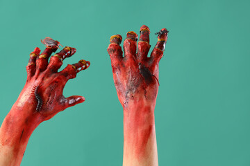 Bloodstained zombie hands on green background. Halloween celebration