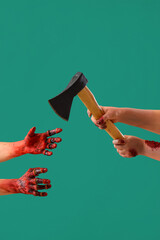 Zombie hands with axe on green background. Halloween celebration