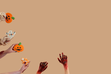 Zombie and mummy hands holding Halloween cookies on beige background