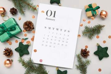 Paper calendar for January 1 with gift boxes and Christmas decorations on grey background - obrazy, fototapety, plakaty