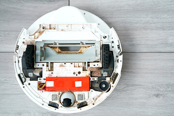 Repairing a robot vacuum cleaner that is clogged with dirt and hair. Disassembled robot vacuum...