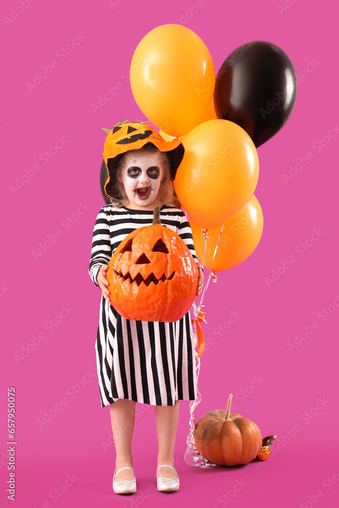 Wall mural little girl dressed for halloween with pumpkin and balloons on purple background