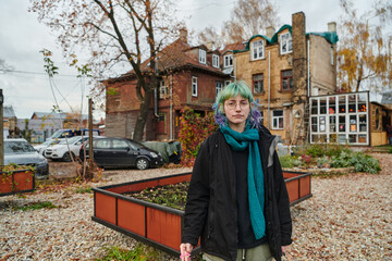 A captivating portrait of a young, interesting girl with striking blue hair, taken in the park in...