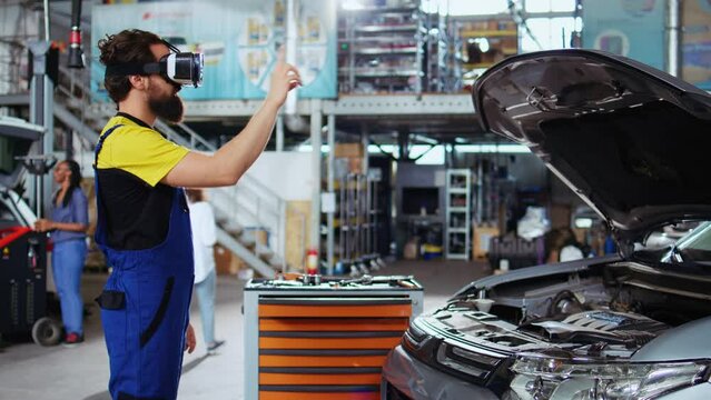 Trained technician in auto repair shop using virtual reality goggles to visualize car components in order to fix them. Man wearing modern vr headset while working on busted vehicle