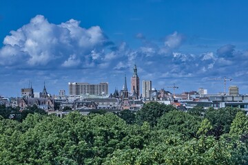 den haag, netherlands - may 30 2022: skyline of the city with historic buildings as also with modern offices with the malieveld and a blue cloudy sky - obrazy, fototapety, plakaty