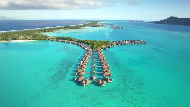 Drone aerial view Bora Bora Tahiti, 4k. Tropical paradise island, turquoise crystal clear water lagoon, overwater bungalows. French Polynesia.