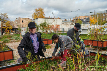 A modern family parents and children, is working together to beautify their front yard with flowers in preparation for the upcoming holiday season.