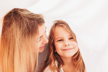 Naklejka premium A mother is looking at her smiling toddler little girl daughter 