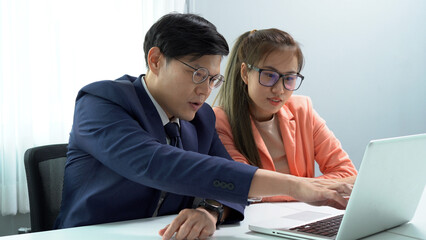 asian business man manager in suit training or teaching new secretary trainee using laptop computer...