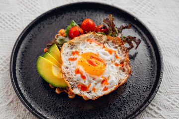 Breakfast waffles, fried eggs, avocado and salad