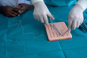 Experts demonstrate how to sew silicone sheets to students of various nationalities, practice...