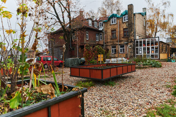 In a charming Lithuanian homestead, a traditional home garden flourishes with vibrant flowers, complemented by large, handcrafted Lithuanian pottery, exemplifying the enduring beauty of cultural