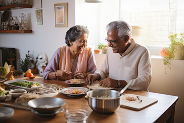 Indian senior couple cooking and having dinner together in kitchen house background.