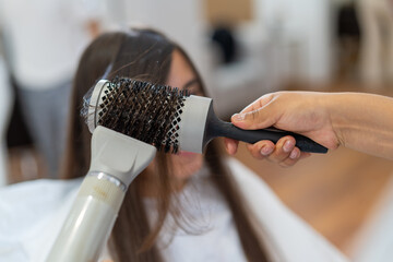 Close-up of a hairdresser curling the hair of a woman