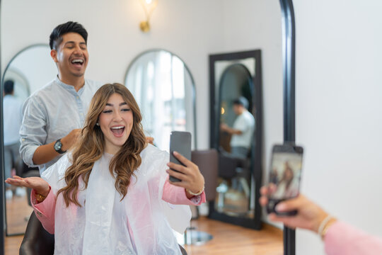 Influencer taking a selfie with a professional hairdresser in a salon - Powered by Adobe