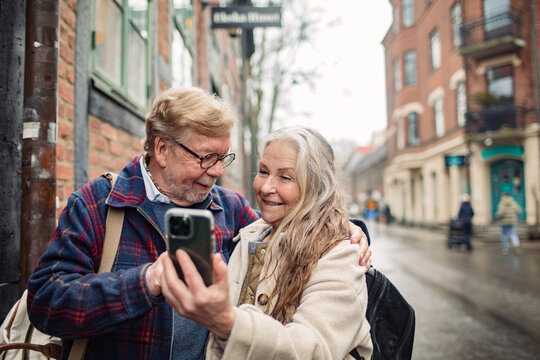 Senior couple using a smartphone in the city while on vacation