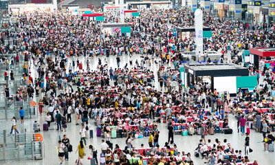 Large group of people waiting at train station hall