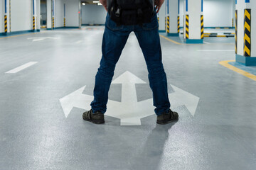 Man legs standing in front of three direction arrows