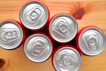group of aluminium red cans soft drink put on brown wooden table
