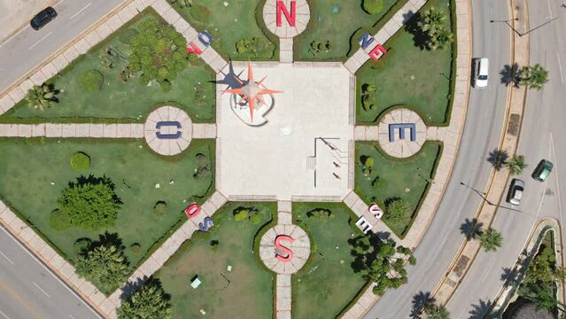 Obelisk with wind rose in Square of Disoriented or San Juan Bautista in San Juan de la Maguana, Dominican Republic. Aerial top-down ascending