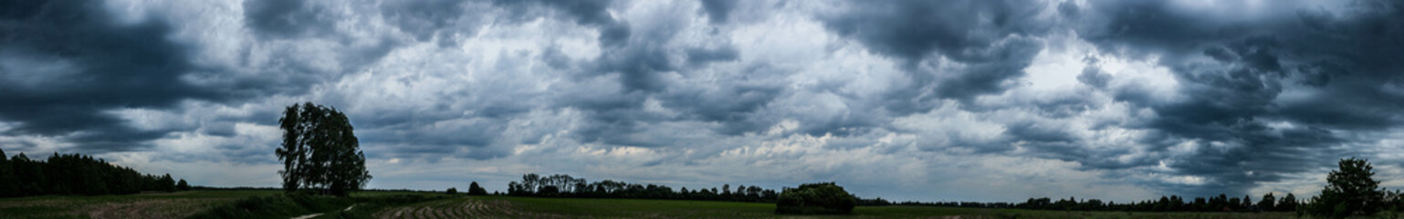panorama of beautiful moving clouds over a field
