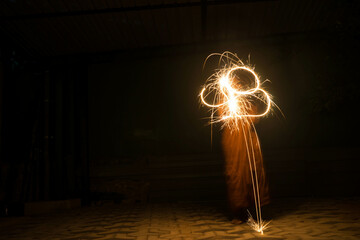 a person playing with fire crackers in the dark