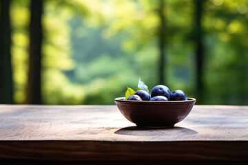 Bowl of fresh plums sitting on rustic wooden table. Perfect for food and nutrition-related content.