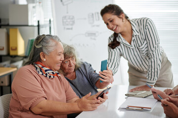 Fototapeta premium Senior women learning how to take seflie in class for older people