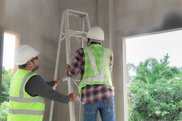 Asian or Indian contractor man business partnership inspect ceiling room mistake labor working...