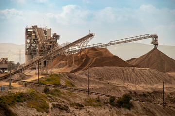 Conveyor belts transporting rocks onto large mounds of gravel