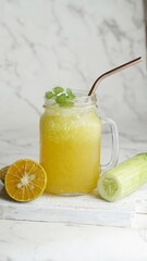 cucumber and squeezed orange in a jar. Isolated on white marble