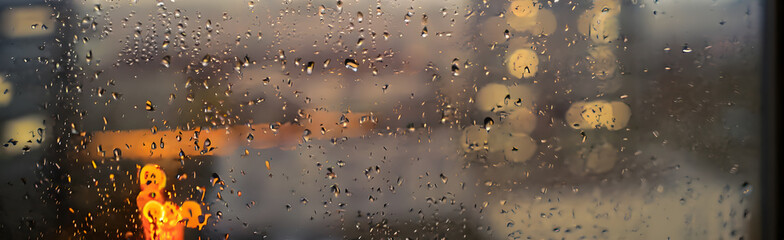 window with raindrops on a stormy day in the city
