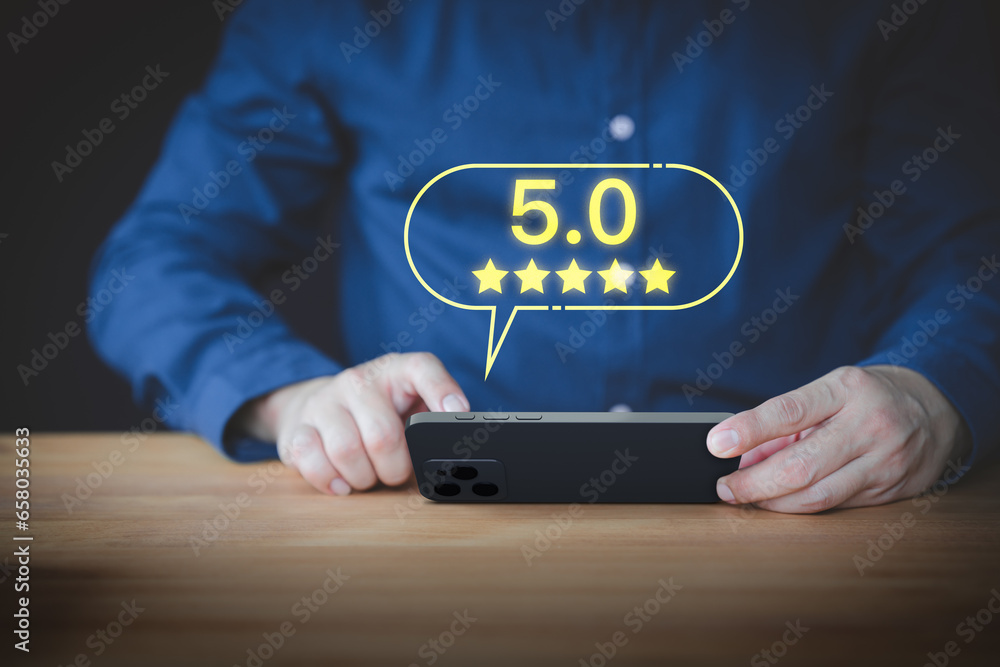 Leinwandbilder user hand using a mobile phone with pop up five stars icon for feedback review satisfaction service 