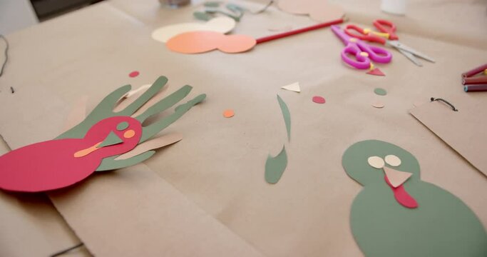 Coloured paper, crayons, scissors and cutouts lying on table
