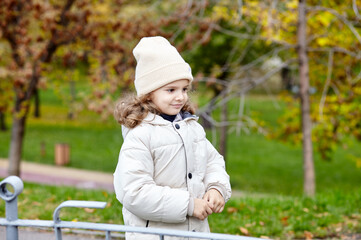 Baby girl are walking in the autumn city park. Little child having fun outdoors. Autumn season. Childhood