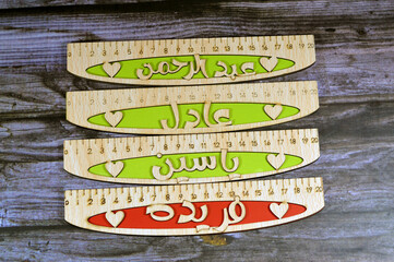 Translation of Arabic Names on rulers ( AbdulRahman, Yassin, Adel, Farida) Arabian common names on wooden rulers, a rule, line gauge, instrument used to make length measurements in centimeters - obrazy, fototapety, plakaty