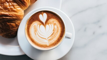 A stunning overhead shot of a cappuccino with a perfect foam heart, set on a marble table with a croissant on the side, focusing on the arrangement and natural light.