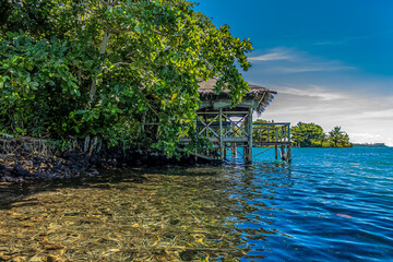 White Cirrus clouds over a lagoon in Samoan fale or hut or house  over calm blue water. A romantic quiet place for love and relaxation. Beauty clear cloudy in sunlight calm air background