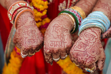 Three women showing henna designs on their hands at Indian wedding
