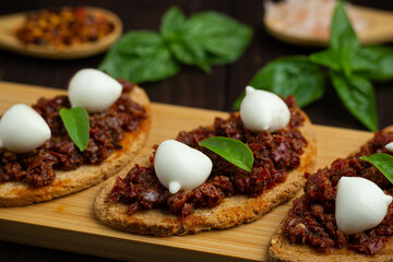 Bruschetta with dried tomatoes, mozzarella, garlic and olive oil. Traditional Italian cuisine...