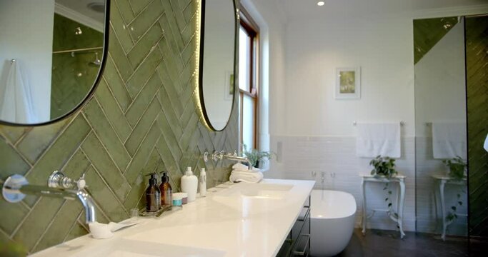Beautiful mirrors, taps, sinks and green walls in sunny bathroom