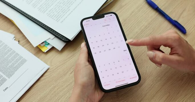 Secretary using calendar application on mobile device. Planning and scheduling things for future