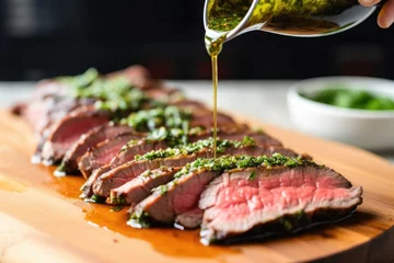 Foto op Canvas spooning chimichurri sauce on grilled flank steak © Alfazet Chronicles