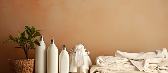 Laundry on a clothesline with the backdrop of a beige wall and a houseplant includes white linen colored clothes a basket and cleaning products