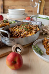 Tasty lasagna with braised and shredded meat, mushrooms and cheese in a casserole dish