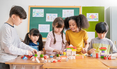 Portrait of asian caucasian little children playing blocks in classroom. Learning by playing education group study concept. International pupils doing activities brain training in primary school. - Powered by Adobe